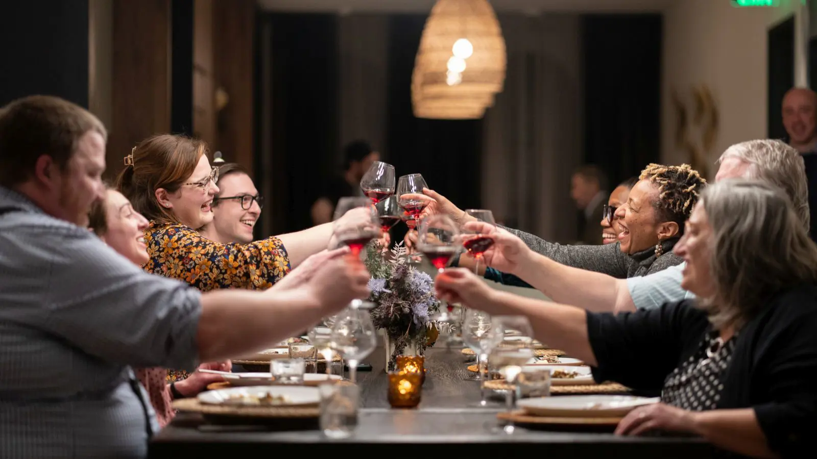 Group of people raising glasses of wine in celebration.